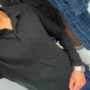 Svart pikétröja från Selected Homme - Säljer en stilren svart pikétröja från Selected Homme i storlek M. Tröjan är långärmad och gjord av fibrer, vilket gör den både bekväm. Perfekt för både vardag och lite mer uppklädda tillfällen. Passar bra till jeans eller chinos!