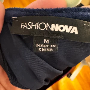 Flerfärgad klänning från Fashion Nova - Säljer en supercool flerfärgad klänning från Fashion Nova i storlek M. Klänningen har en tight passform och är gjord i ett mjukt, stretchigt material. Den har långa ärmar och ett mönster i vinröd, beige och svart som verkligen sticker ut. Perfekt för en festkväll eller en utekväll med vänner!