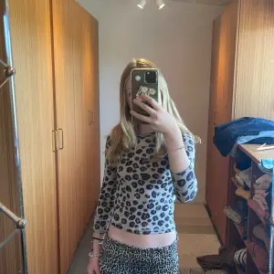 Säljer en supercool leopardmönstrad topp med långa ärmar. Den är tight och croppad, perfekt för en trendig look. Materialet känns som bomull och den har en beige bas med svarta fläckar. Perfekt för både vardag och fest! väldigt trendig just nu! säljer för jag inte får någon användning av den men hoppas du kan. den är i Super bra skick💞