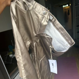Guld byxor - Helt oanvända med lappen kvar. Kom aldrig till användning och är för små för mig nu tyvärr. Lowwaist och vida ben. 