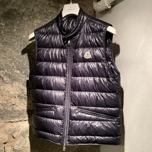 Moncler Vest - Säljer min Moncler vest då jag vuxit ur den. Sparsamt använd och är i perfekt skick. Storlek 3 vilket motsvarar ca. M. Inköpt på NK Göteborg 2023-04-12, kvitto finns. Extra knappar, Moncler galge ingår. Nypris 6999kr. Hör av er vid frågor eller bild