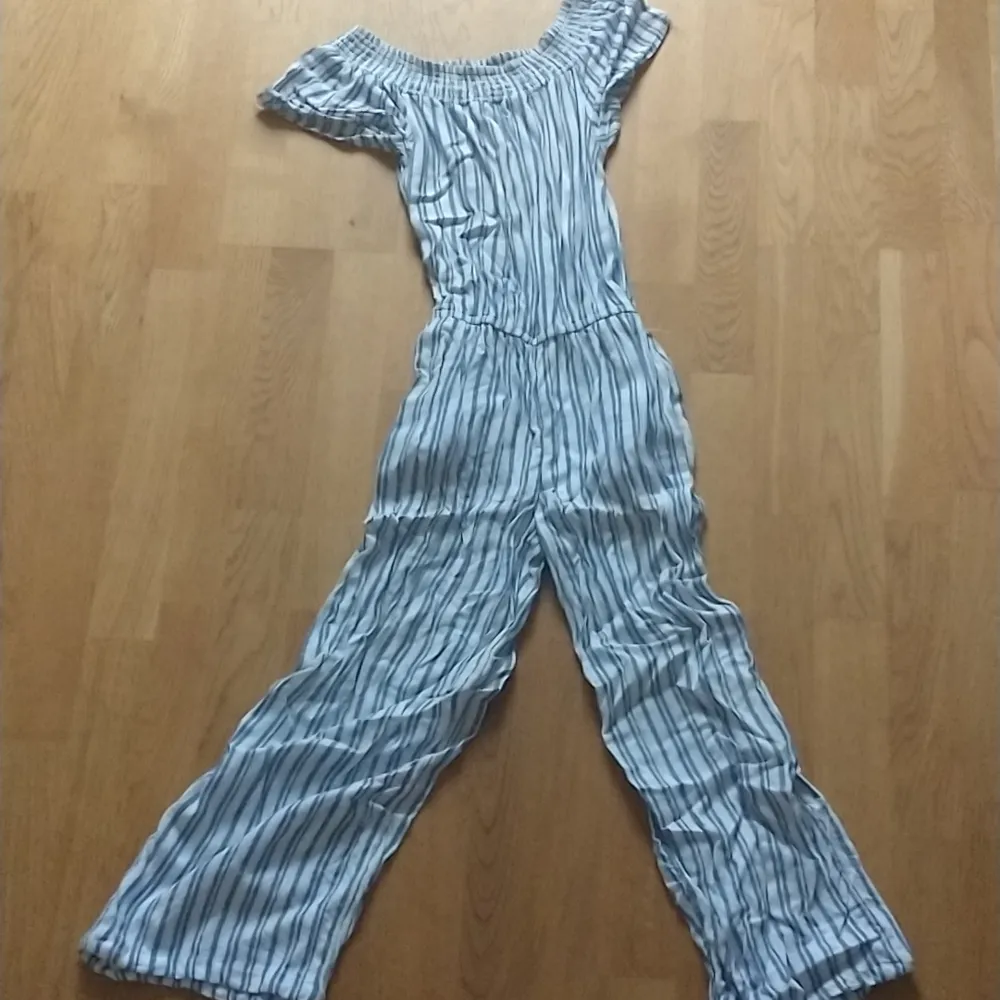 Säljer en superfin randig jumpsuit från Hampton Republic. Den är blå och vit, kortärmad och en bekväm passform. Perfekt för sommardagar eller en avslappnad fest. Materialet känns lätt och luftigt, vilket gör den idealisk för varma dagar. 🦋. Klänningar.