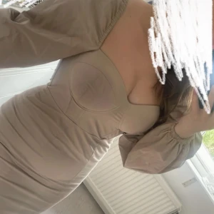 Beige mini klänning  - En mini klänning som har en jättefin siluett. Använd en gång. 