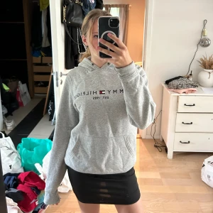 Grå märkes hoodie - Grå Tommy Hilfiger hoodie. Storlek s. Mycket använd och super skön. Håll längst ner på ärmen.