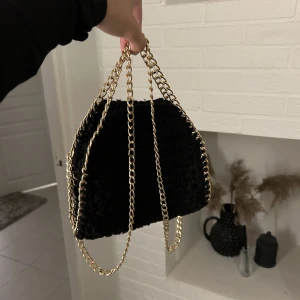 Virkad väska  - Virkad svart väska med guldkedja. Handgjord oanvänd i superfint skick. Köparen står för frakt ❤️ skriv för fler bilder! 