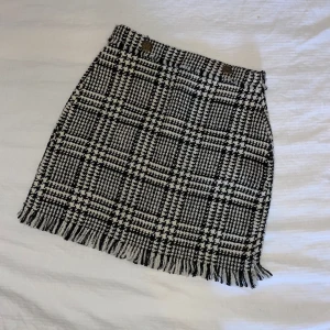 Rutig kjol zara - Kjol från Zara. Använd ett fåtal gånger. Kommer med extraknapp. Funkar att ha på hösten/vintern med strumpbyxor. Passar strl 36/34 skulle jag säga. 