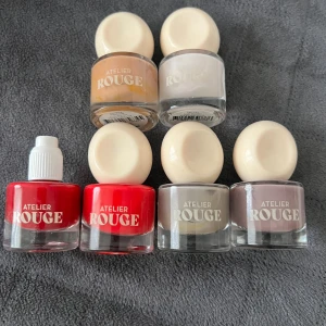 Nagellack från Atelier Rouge - Säljer ett set med sex olika nagellack från Atelier Rouge. Färgerna inkluderar en klassisk röd, en ljusare röd, beige, ljusgrå, och två olika nyanser av grått. Perfekt för att matcha olika outfits och humör! Flaskorna har en rund vit kork och är superenkla att använda. köpt för 70kr st men säljer för 40kr st, testade bara, den utan lock säljs för 25kr! ANNARS köps alla för 170kr <33