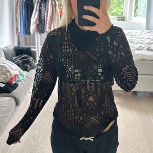 Svart mönstrad topp från Margit Brandt - Säljer en supercool svart topp från Margit Brandt. Den är långärmad och har ett unikt geometriskt mönster. Toppen är genomskinlig och har en tight passform, extra lager vid halsen. vet inte vad storleken är men uppskattar till en S. Nypris är cirka 700