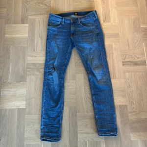 Blå jeans från Lee - Snygga blå jeans från Lee med en klassisk femficksdesign. De har en slim passform och är tillverkade i ett slitstarkt denimtyg. Perfekta för en stilren look.