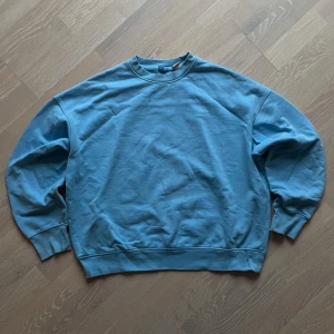 Blå sweatshirt från Levi's - Säljer en blå sweatshirt från Levi's med boxy passform och broderad logga på bröstet. Den har sina defekter lite här o där (se bilder). Bild 5 visar ett märke som blev till när jag glömde fläckborttagning på lite för länge (det råkade frätas bort lite)😞. 