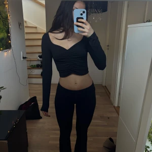 Svart långärmad med sweetheart neckline - Så söt svart långärmad topp, med scrunch i mitten och jättefin ringning. Mjukt material och fin croppad längd