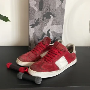 Röda skor från Valentino - Snygga röda och vita grish skor från Valentino med snörning. Skorna har en klassisk design med en vit sula och röda detaljer. Perfekta för en stilren look. Skicket är använt men fortfarande bra. Box och skosnören ingår. Vid frågor är det bara att höra av sig!