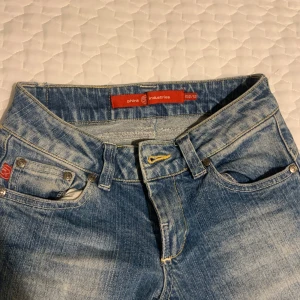 Blå jeans från Phink Industries - Snygga blå jeans från Phink Industries med klassisk femficksdesign och knappgylf. De har en bekväm passform och är perfekta för en avslappnad stil. Märkesdetaljer på fickan och bältesslingor för att enkelt kunna matcha med ett bälte.⚠️kolla sista bilden för se skavankerna. Dom är i storlek 152