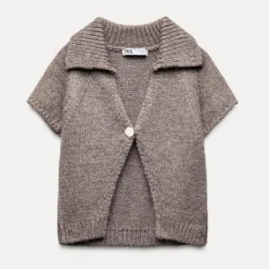 Beige stickad kofta från Zara - Säljer en mysig beige stickad kofta från Zara med korta ärmar och en stor knapp framtill. Perfekt för lager-på-lager-stil under svalare dagar. Koftan har en bred krage och ribbade kanter för extra stilpoäng. Skulle säga att den är liten i storleken❣️