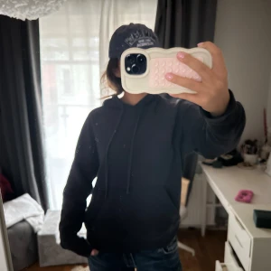 Svart hoodie med tryck - Säljer en svart hoodie med ett unikt tryck på ryggen. Köpte den i new york förra året och den är väl andvänd men i bra skick!