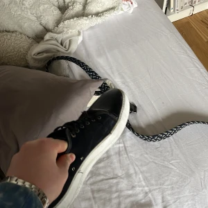 Svarta sneakers med vit sula - Snygga svarta sneakers med vit sula och snörning. Perfekta för en avslappnad stil och passar till många olika outfits.