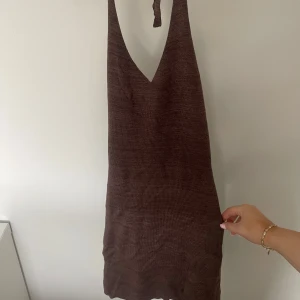 Stickad miniklänning  - Fin stickad klänning från bikbok med prislapp. Super skön och snygg! Öppen rugg med knytning runt halsen!