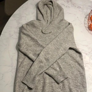 Grå Merinoull/kashmir hoodie - Säljer nu denna skit snygga gråa merinoull hoodie eftersom den är lite för liten för mig. Jag är 181 cm men den sitter väldigt kort i armarna killen jag köpte den av säger att det är strl S men jag skulle säga att den passar som xs. Hör av er vid fler frågor!🍾😊