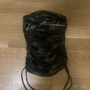 camo print med pärltext  - jätte gullig tube top med camo print och text. inga defekter och fick det av en vän så vet ej vart det kommer från. skriv för mer info!