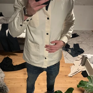 Beige overshirt från Les Deux - Snygg beige overshirt från Les Deux med svarta knappar och två praktiska fickor framtill. Perfekt för lager-på-lager-stil och ger en stilren look. Passar bra till jeans eller chinos. Köpte jackan den 25/2 och är helt enkelt suget på något annat. Jackan är 10/10 i skick med till och med prislappen kvar. Säljer den för endast 800 kr fast nypris är 1500. Först till kvarn. Mvh Albin 