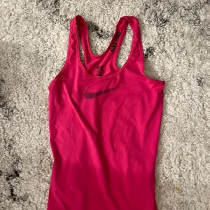 Nike Pro träningslinne - Ceriserosa stretchigt linne från Nike Pro med brottarrygg i strl S, men passar även mig som är XS 🩷