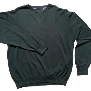 Mörkgrön tröja från Tommy Hilfiger - Säljer en stilren mörkgrön tröja från Tommy Hilfiger. Tröjan har långa ärmar och ribbade muddar vid ärmslut och nederkant. Perfekt för en avslappnad och bekväm stil.