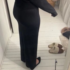 Svart långkjol - Snygg svart långkjol med en tight passform. Köpt i somras och bara använd ett fåtal gånger. Skulle säga att materialet är lite som träningskläder vilket gör att den formar sig väldigt fint på kroppen.