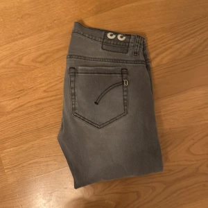Grå jeans från Dondup (george) - Snygga grå jeans från Dondup med en klassisk femficksdesign. De har en knappgylf och bälteshällor för en perfekt passform. Perfekta för en stilren look. In princip helt nya använda fåtal gånger inga defekter alls
