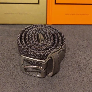 Flätat Bälte i Grått - Snyggt flätat bälte i grått. Helt nytt. Skick 10/10. 105 cm långt 