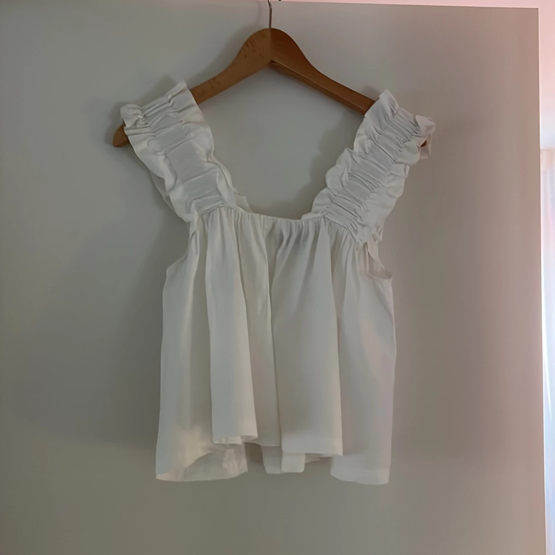 Vit topp med volangdetaljer från Gina Tricot