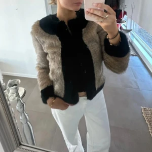 Beige och svart pälsjacka från U.F - Säljer en snygg beige och svart pälsjacka från U.F. Mycket bra skicka och knappt använd. Såååå fin och passar till allt😍 Storlek XS men skulle säga att den också passar S (dock kanske inte om man vill ha en tjocktröja under). Kom gärna med bud 🥰