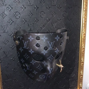 Svart mask med monogram - Unik svart mask med monogrammönster av äkta LV läder men ej originell design från LV Utan från ”emilush” som designat liv accessoarer till kändisen Joakim Lundell osv