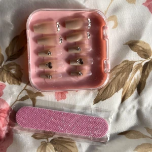 Nagelkit - Sött nagelkit med lösnaglar. Kommer i en praktisk rosa förvaringsask. Inkluderar en rosa nagelfil för enkel applicering och formning . Perfekt för speciella tillfällen.