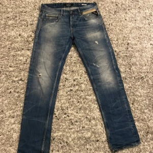 Blå jeans från Replay - Säljer ett par snygga blå jeans från Replay med en sliten look.  Knappt använda, skick 9/10 