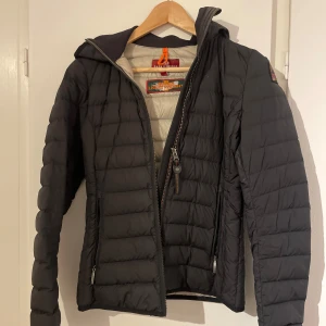 Svart dunjacka från Parajumpers - Säljer en svart dunjacka från Parajumpers i mycket bra skick. Jackan är superlätt och har en dragkedja framtill. Perfekt för höst och vår med sin quiltade design och långa ärmar. Den är både snygg och praktisk för kyligare dagar. Jackan har foundation fläckar på luvan som jag ej får bort. Köpte för ungefär 3k säljer för 999:-, pris går alltid att diskutera 