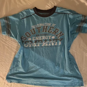 Blå t-shirt från Nex - Säljer en blå baby tee från Nex med tryck på framsidan. T-shirten har korta ärmar och en rund halsringning med mörkare kant. Perfekt för en avslappnad stil. Älskar denna tröjan men färgen passar inte mig 🫶☹️ den är i en S/M