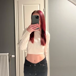 Vit stickad croppad tröja - Säljer en superfin vit stickad tröja med flätat mönster från H&M. Den är croppad och har långa ärmar. Tröjan är i mycket bra skick och är endast använd fåtal gånger. 