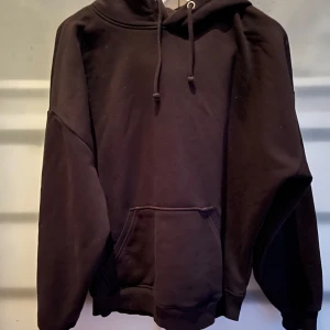 Svart hoodie från BikBok - Säljer en svart hoodie från BikBok i storlek M. Den är väldigt skön att ha på sig. Hoodien har en klassisk design med känguruficka och justerbar dragsko i huvan. Perfekt för en avslappnad stil eller mysiga hemmakvällar. 🖤
