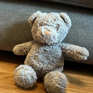 Grå nallebjörn från Ecofriends - Mysig och mjuk grå nallebjörn från Ecofriends. Perfekt som kramkompis eller dekoration i barnrummet. Tillverkad av mjukt material som är skonsamt mot huden. En söt och hållbar leksak för alla åldrar.