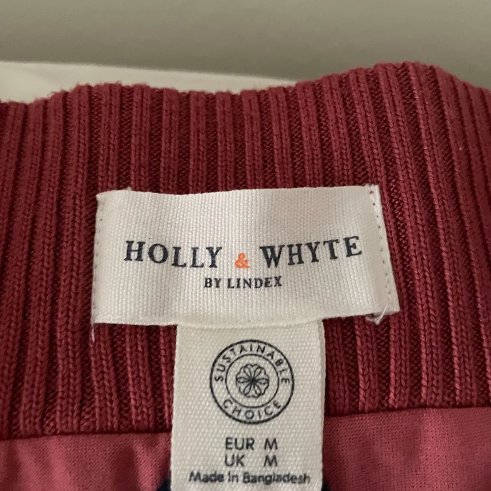 Säljer en elegant vinröd kjol från Holly & Whyte by Lindex. Kjolen har ett ribbat mönster och är perfekt för höst och vinter. Den är i mycket bra skick och passar både till vardag och fest. Hållbar och stilren design!. Kjolar.