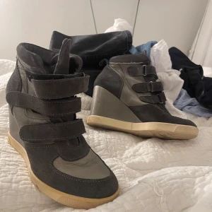 Grå sneakers med kilklack - Snygga grå sneakers med kilklack och kardborreband. Perfekta för en stilren look med en twist. Skorna har en beige sula som ger en fin kontrast.