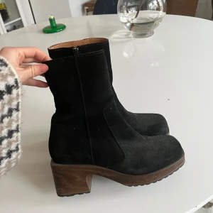 Svarta mocka boots från Calou - Snygga svarta boots i mocka från Calou Stockholm. De har en mjuk, lätt och böjbar sula.  Dragkedja på sidan för enkel på- och avtagning. Perfekta för både höst och vinter.