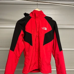 Röd och svart jacka från The North Face - Säljer en snygg röd och svart jacka från The North Face. Perfekt för höst och vinter med långärmad design och dragkedja. Jackan har en sportig look och är i mycket bra skick. Passar perfekt för utomhusaktiviteter. Säljes i befintligt skick. Storlek: M