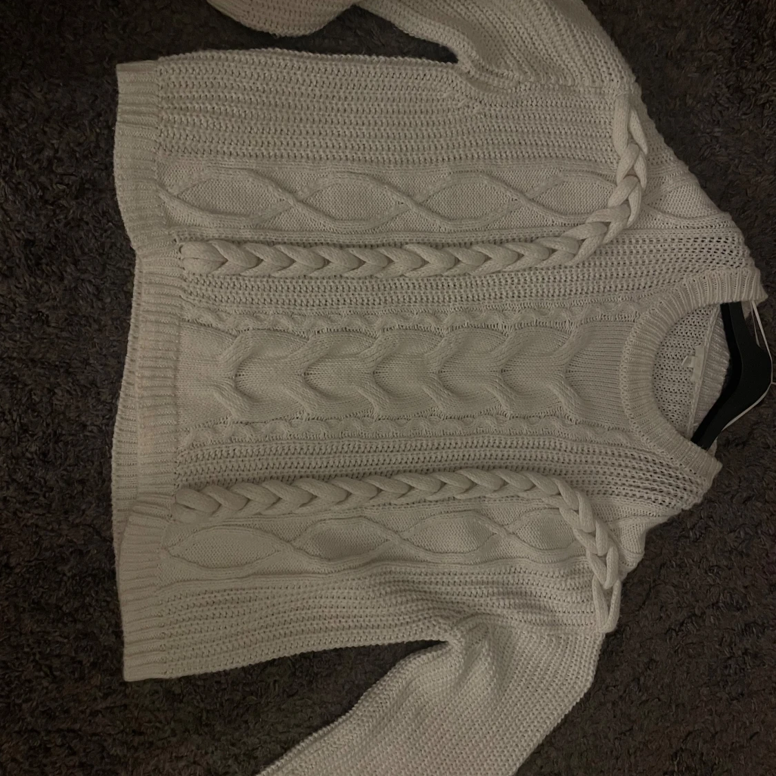 Vit stickad tröja med flätmönster