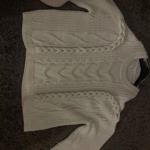 Vit stickad tröja med flätmönster - Säljer en superfin vit stickad tröja med snyggt flätmönster. Perfekt för kyliga dagar! Tröjan har långa ärmar. Den är köpt på hm för 500kr har bara haft den vid ett tillfälle. 