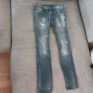 Blå jeans från G-Star - Säljer ett par snygga blå jeans från G-Star i bra skick. De har en cool slitningseffekt och en tight passform som ger en modern look. Perfekta för både vardag och fest! 🕺
