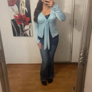 Ljusblå knyttröja - Säljer en superfin ljusblå tröja med knytning framtill. Den har långa ärmar och är perfekt för både vår och sommar. Tröjan är i bra skick och passar perfekt till jeans för en avslappnad look. Perfekt för en dag ute eller en mysig fika med vänner! 💙