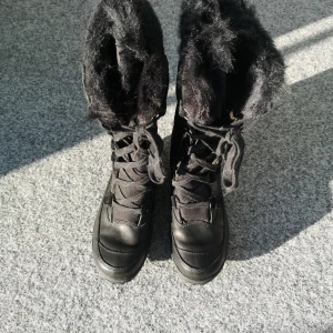 Svarta vinterstövlar från Timberland - Svarta vinterstövlar i skinn och vattenavisande material från Timberland, fodrade med mockadetaljer.  