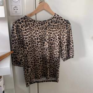 Säljer en snygg leopardmönstrad topp med trekvartsärm. Perfekt för att ge din outfit en vild touch! Toppen är i ett mjukt material och har en normal passform. Passar både till vardags och fest. 🐆✨