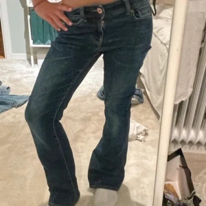 Blå jeans från American Eagle - Säljer ett par snygga blå jeans från American Eagle i super stretch material. De är bootcut och lågmidjade, vilket ger en skön passform. Perfekta för både vardag och fest! 🕺 PRIS KAN DISKUTERAS 